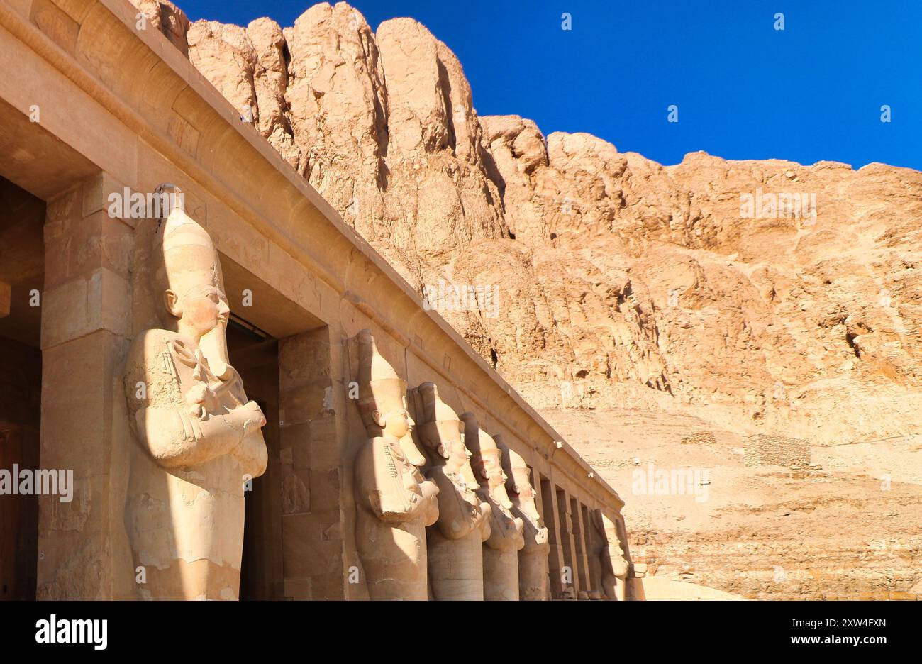 Massive Statuen der großen weiblichen Pharoah Hatschepsut mit dem Gauner und Schlegel als Herrscher Ägyptens in Sandstein dominieren die äußeren Säulen des Leichentempels in der Nähe von Luxor, Ägypten Stockfoto