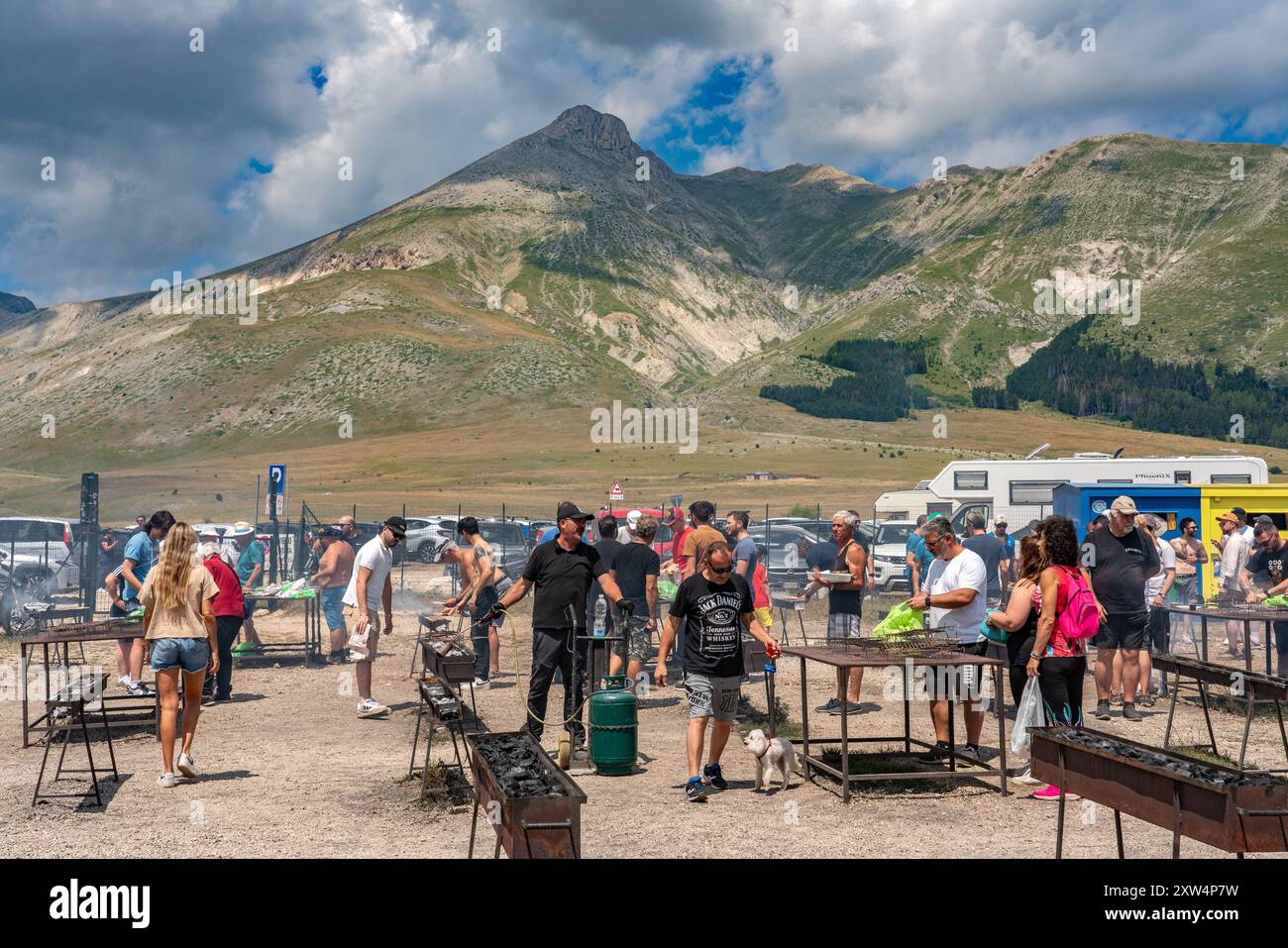 Unter der Sommersonne verbringen eine Vielzahl von Menschen einen festlichen Tag mit dem Grillen von Fleisch im Gran Sasso und Monti della Laga Nationalpark. Abruzzen, Italien Stockfoto