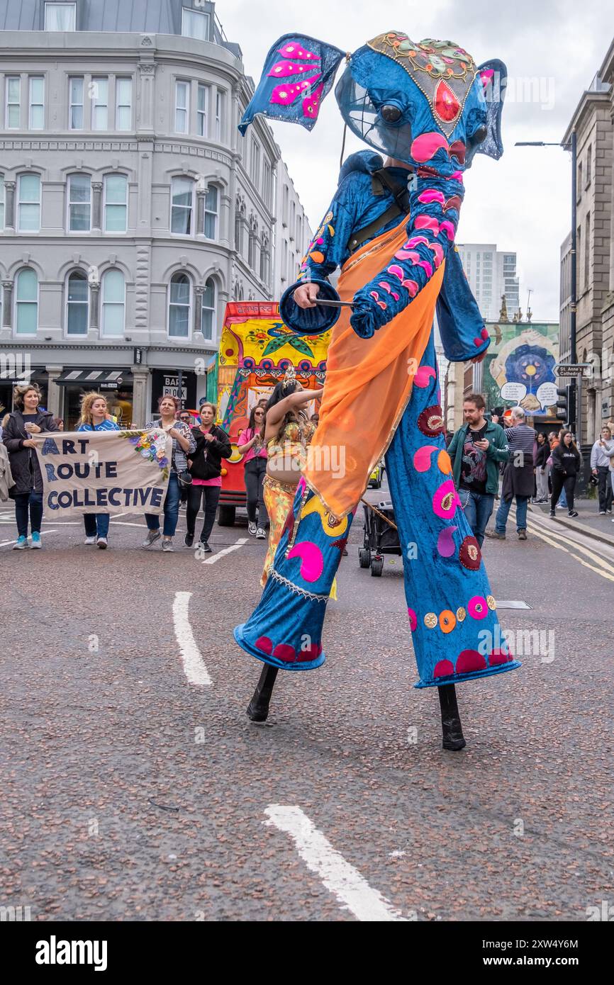 Belfast Mela multikulturelle Karnevalsparade - Person in einem aufwendigen dekorativen blauen Elefantenkostüm, der auf Stelzen läuft. Belfast, Großbritannien - 17. August 2024. Stockfoto