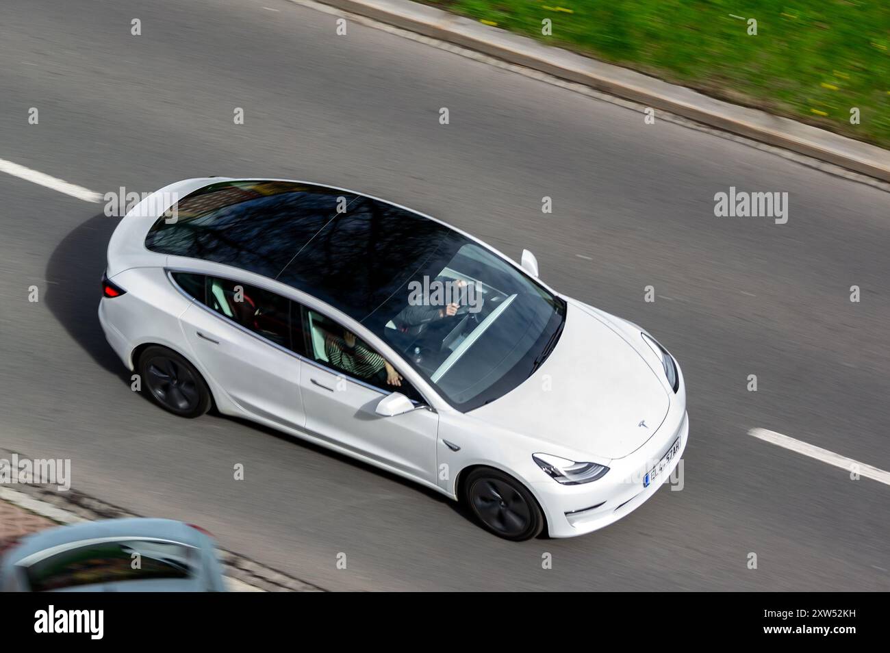 OSTRAVA, TSCHECHISCHE REPUBLIK - 4. APRIL 2024: Weißes Tesla Model 3 Standard Range Car mit schwarzem Verwackelungseffekt Stockfoto