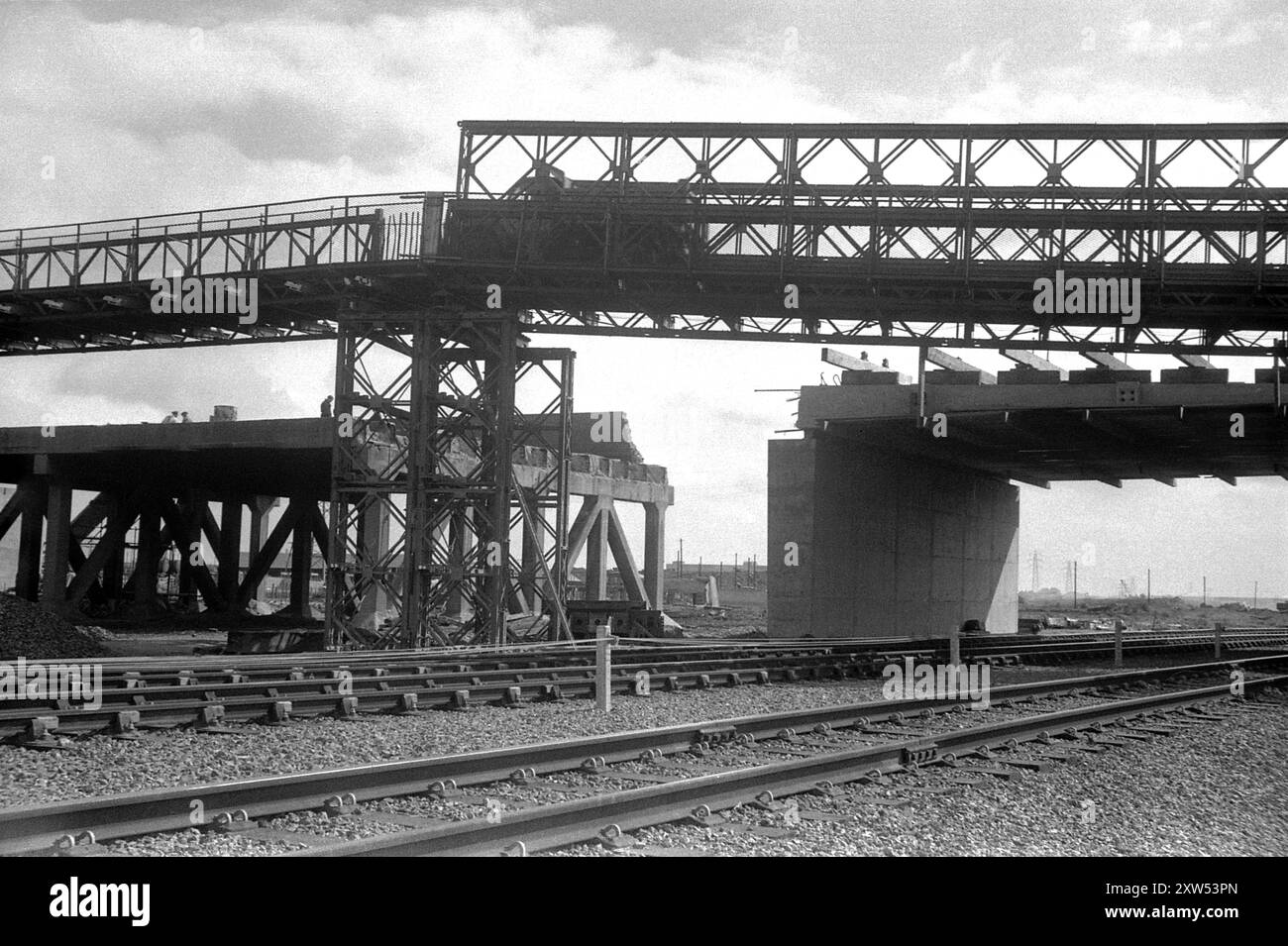 England um 1957 – Eine vorgefertigte Bailey-Brücke, die als provisorischer Ersatz für eine bestehende Straßenbrücke errichtet wurde, die gerade abgerissen wird. Stockfoto