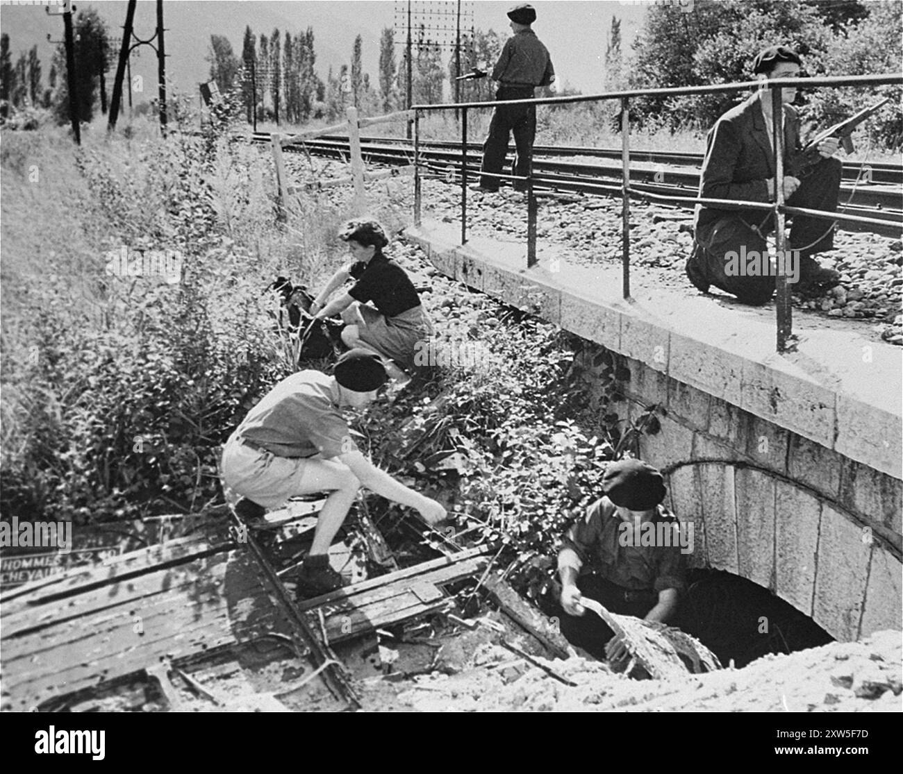 Mitglieder der französischen Widerstandsgruppe Maquis de Voireppe in der Region Chartreuse. Sie demonstrieren, wie man Dynamit unter eine Eisenbahnbrücke bringt, um die Versorgung der nazis zu stören. Das Foto stammt vom 7. September 1944 Stockfoto