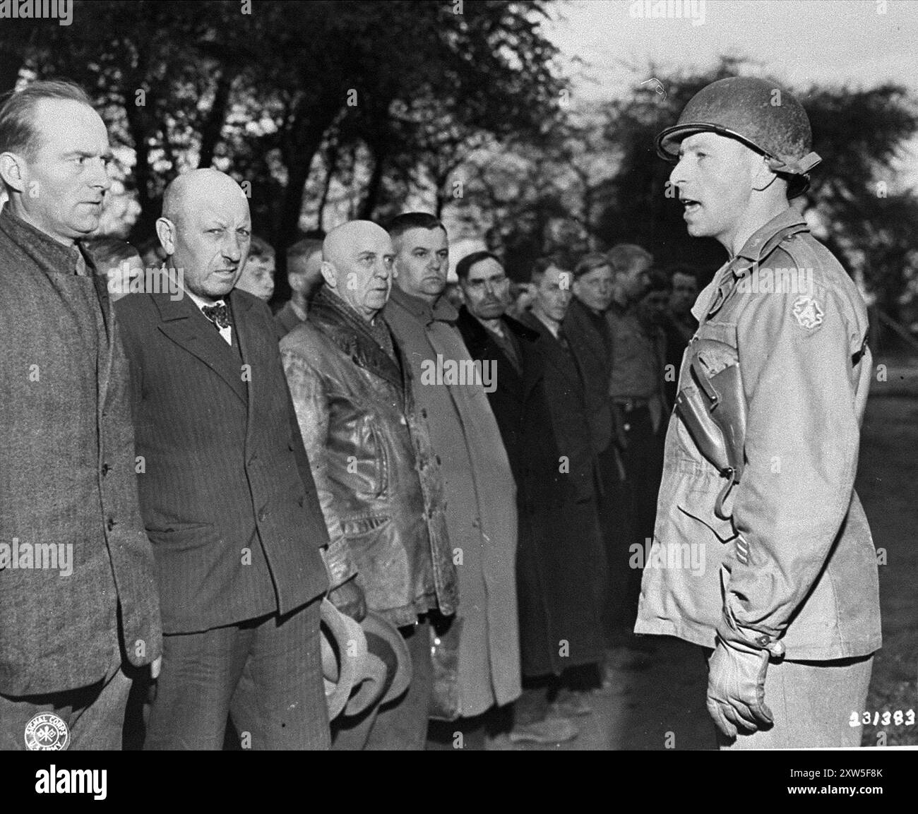 Ein amerikanischer Armeeoffizier spricht mit neu angekommenen deutschen Kriegsgefangenen im Internierungslager Recklinghausen. Dieses Lager war ein sowjetisches Lager für Zivilisten und wurde in ein Internierungslager umgewandelt, um echte Kriegsgefangene nach Kriegsverbrechern zu untersuchen. Stockfoto