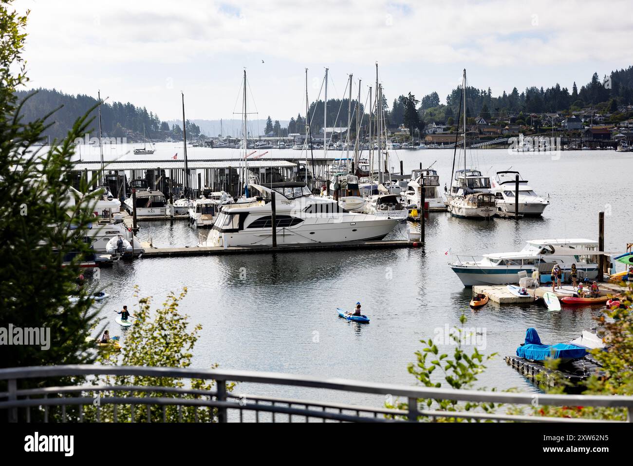 Boote in einem Yachthafen und Kinder lernen an einem Sommertag Kajakfahren in Gig Harbor, Washington, USA. Stockfoto