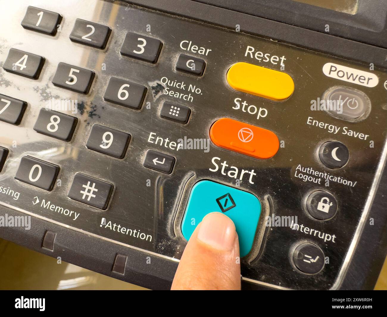 Drücken Sie mit der Hand die Taste auf dem Bedienfeld des Druckers, des Laserscanners des Bürokopiergeräts Verbrauchsmaterial Start Konzept. Stockfoto