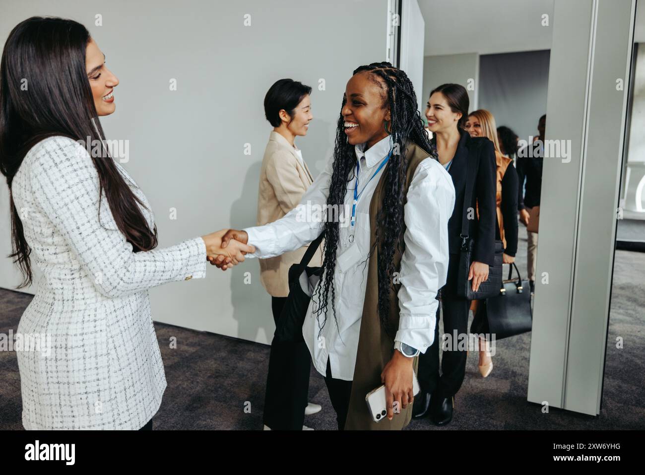Erfolgreiche Profis schütteln bei einer Veranstaltung die Hand, verabschieden sich und tauschen ein Lächeln aus, wenn sie das Meeting verlassen. Stockfoto