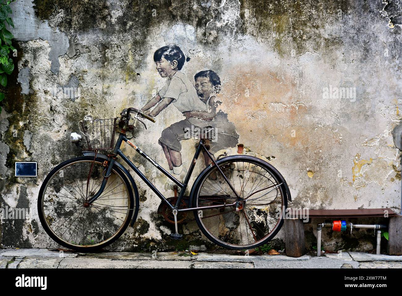 Verspielte Wandbilder und Straßenkunst von Georgetown, Penang, Malaysia. Kinder auf dem Fahrrad Stockfoto