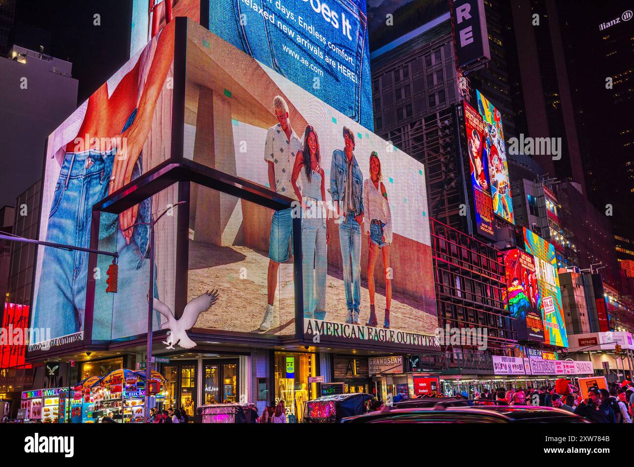 Nachtansicht auf den Broadway am Times Square mit großen Plakaten auf Wolkenkratzern, darunter die prominente Werbung der American Eagle Outfitters. Neu Stockfoto