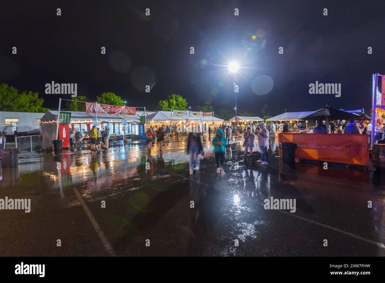 Nächtliche Menge bei Regen bei einem Konzert-Event-Jahrmarkt Karneval Stockfoto