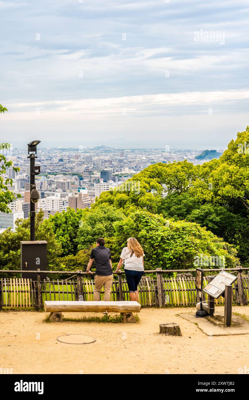 Westliche Touristen, die den Panoramablick auf die Stadt Matsuyama vom Grund der Burg Matsuyama aus in Matsuyama, Shikoku Region, Japan, beobachten Stockfoto