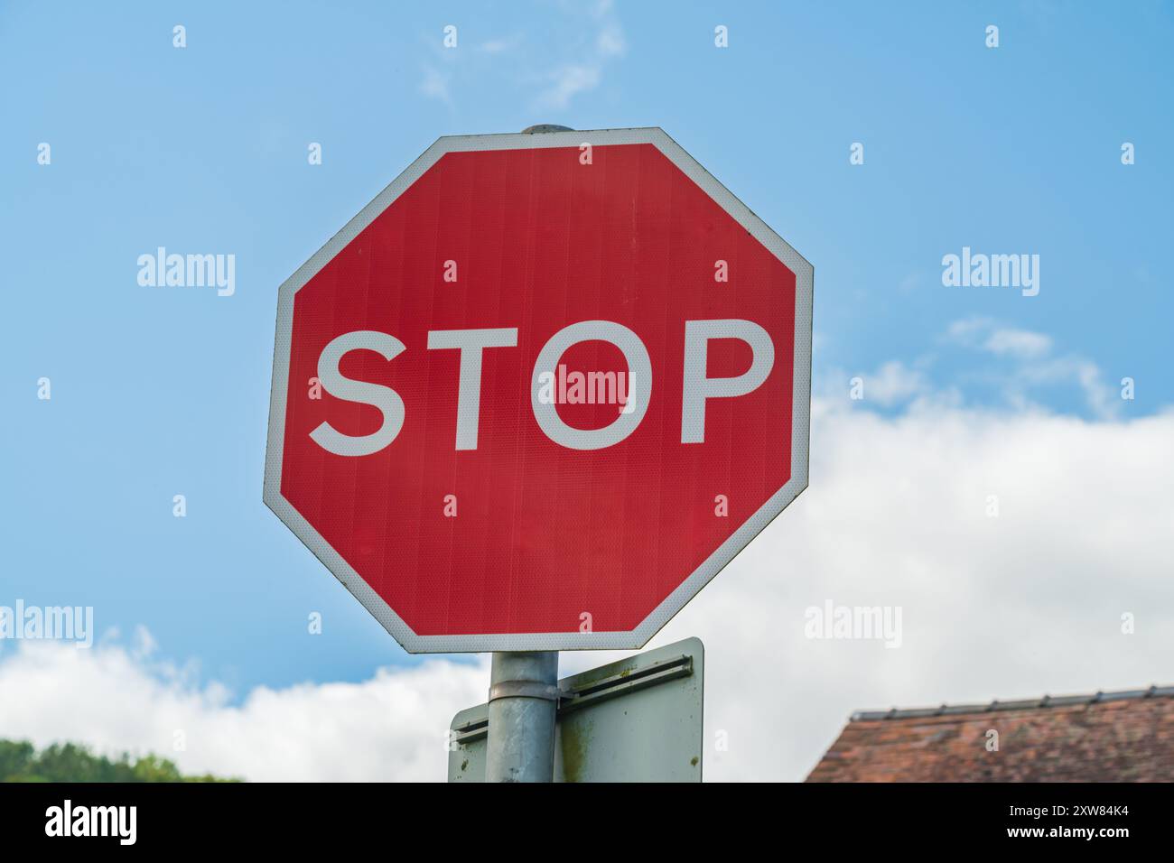 Britisches Verkehrsschild mit Stoppschild und rot-weißem Warnsechskant Stockfoto