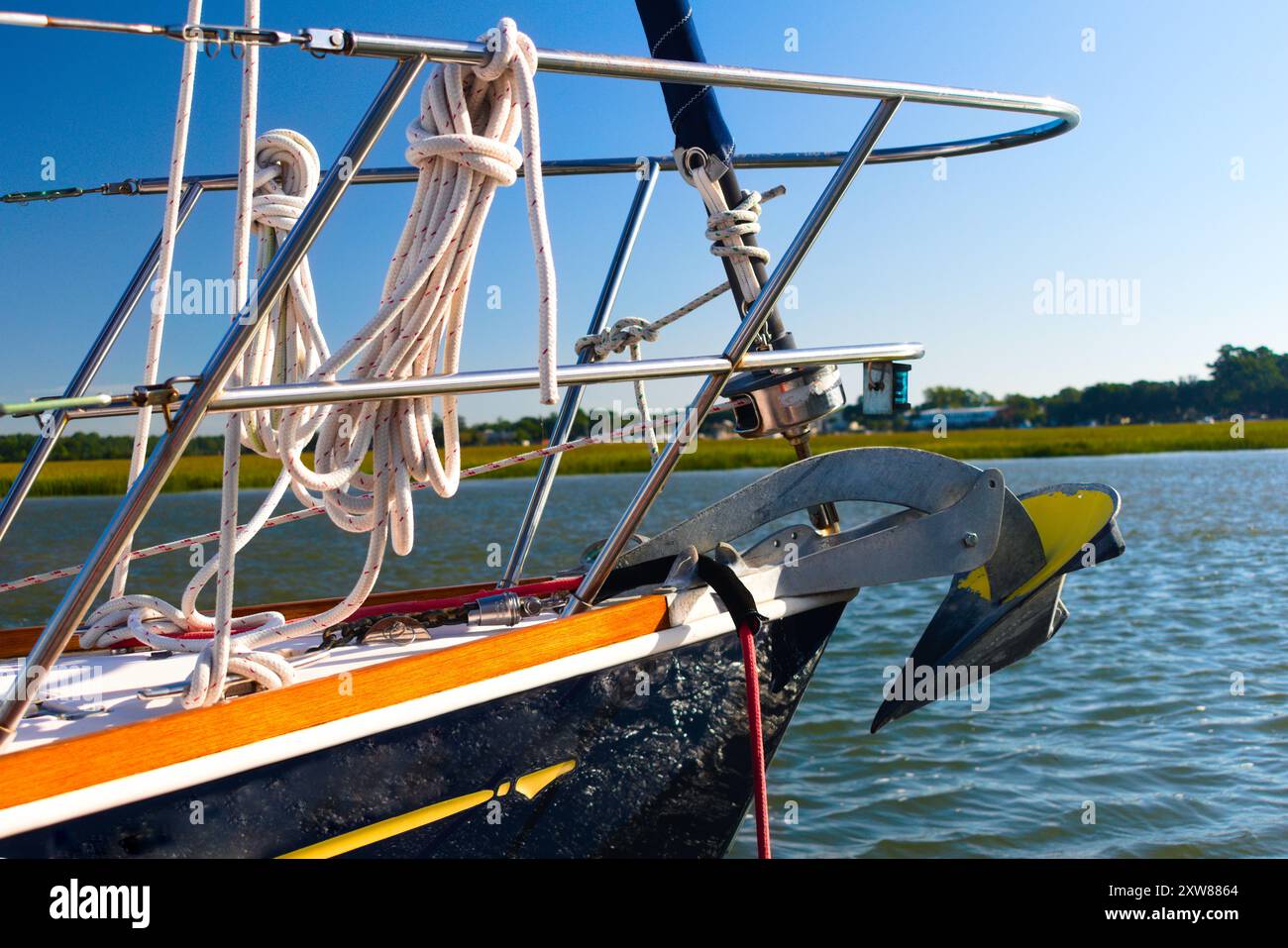 Der Bug eines Segelbootes mit Linien entlang der Schienen mit einem Anker in Position. Stockfoto