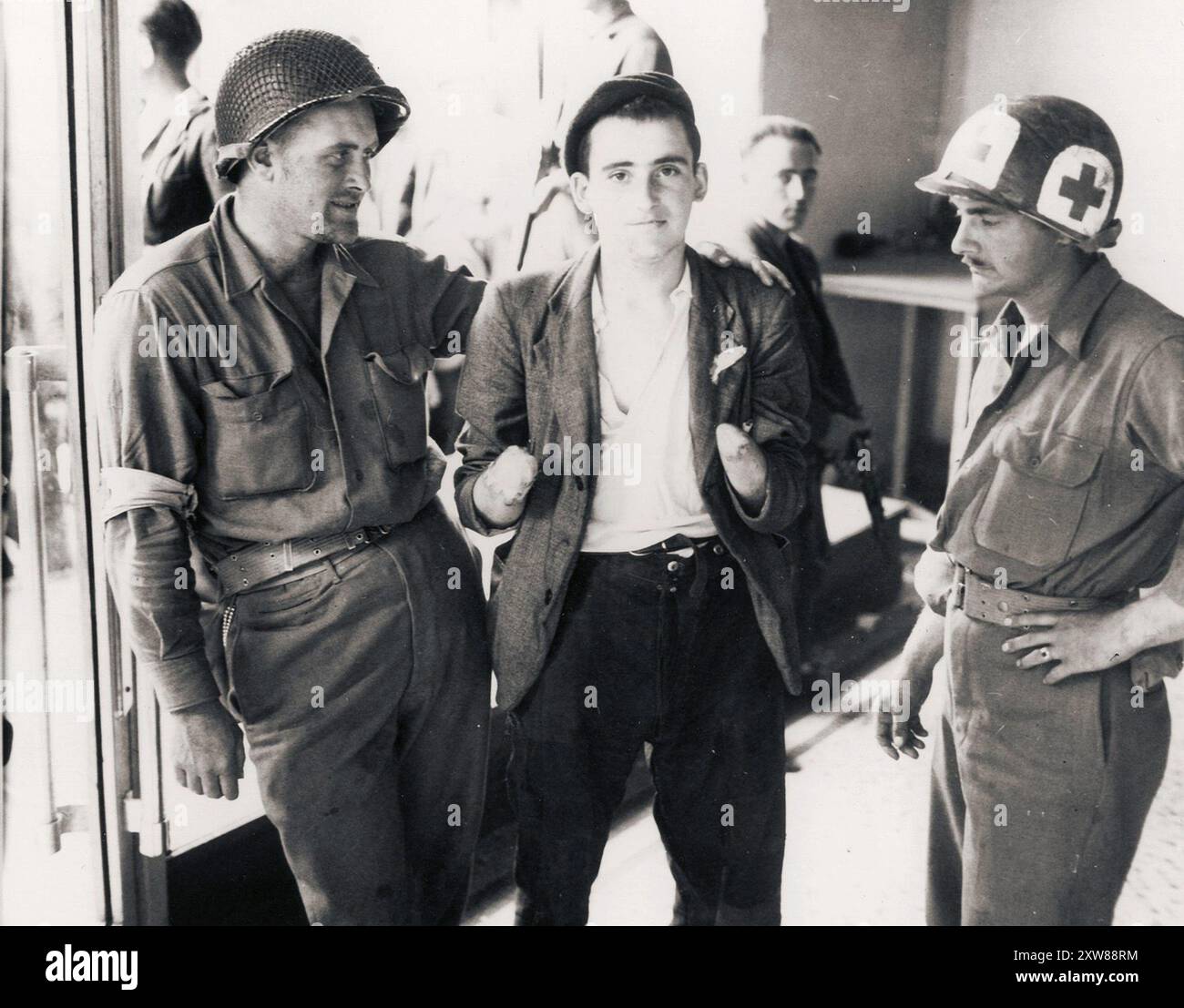 US-Armee-Sanitäter behandeln einen französischen Widerstandskämpfer in Châteaudun in der Loire. Diesem unglücklichen Jungen wurden von den Deutschen beide Hände abgeschnitten. Stockfoto