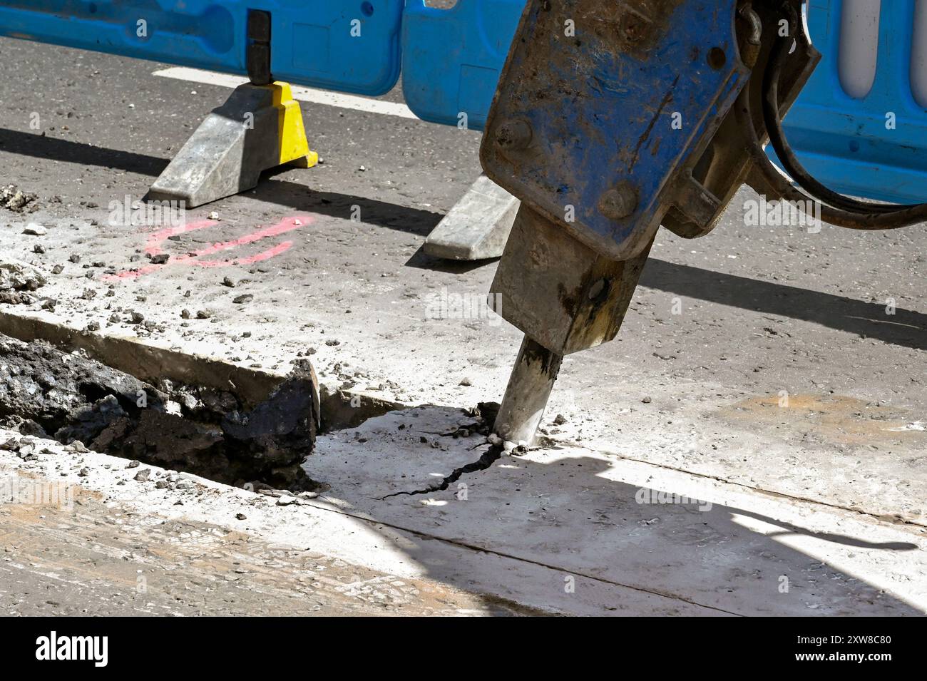 London, England, Großbritannien - 21. Juni 2022: Bagger mit pneumatischem Bohrgerät zum Aufbrechen der Straßenoberfläche einer Straße im Zentrum Londons Stockfoto