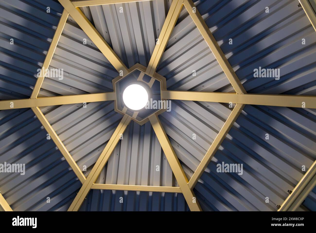 Symmetrisches Dach aus Stahl mit Radialbalken, die auf einem zentralen Oberlicht zusammenlaufen - architektonisches Design mit modernen, klaren Linien. Aufgenommen in Toront Stockfoto