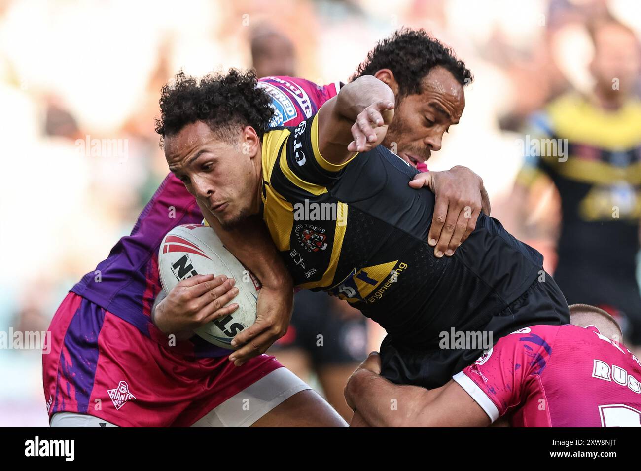 Leeds, Großbritannien. August 2024. Liam Horne von Castleford Tigers wird von Leroy Cudjoe von Huddersfield Giants und Harry Rushton von Huddersfield Giants während des Magic Weekend Matches Huddersfield Giants gegen Castleford Tigers in der Elland Road, Leeds, Großbritannien, 18. August 2024 (Foto: Mark Cosgrove/News Images) in Leeds, Vereinigtes Königreich am 18. August 2024 angegriffen. (Foto: Mark Cosgrove/News Images/SIPA USA) Credit: SIPA USA/Alamy Live News Stockfoto