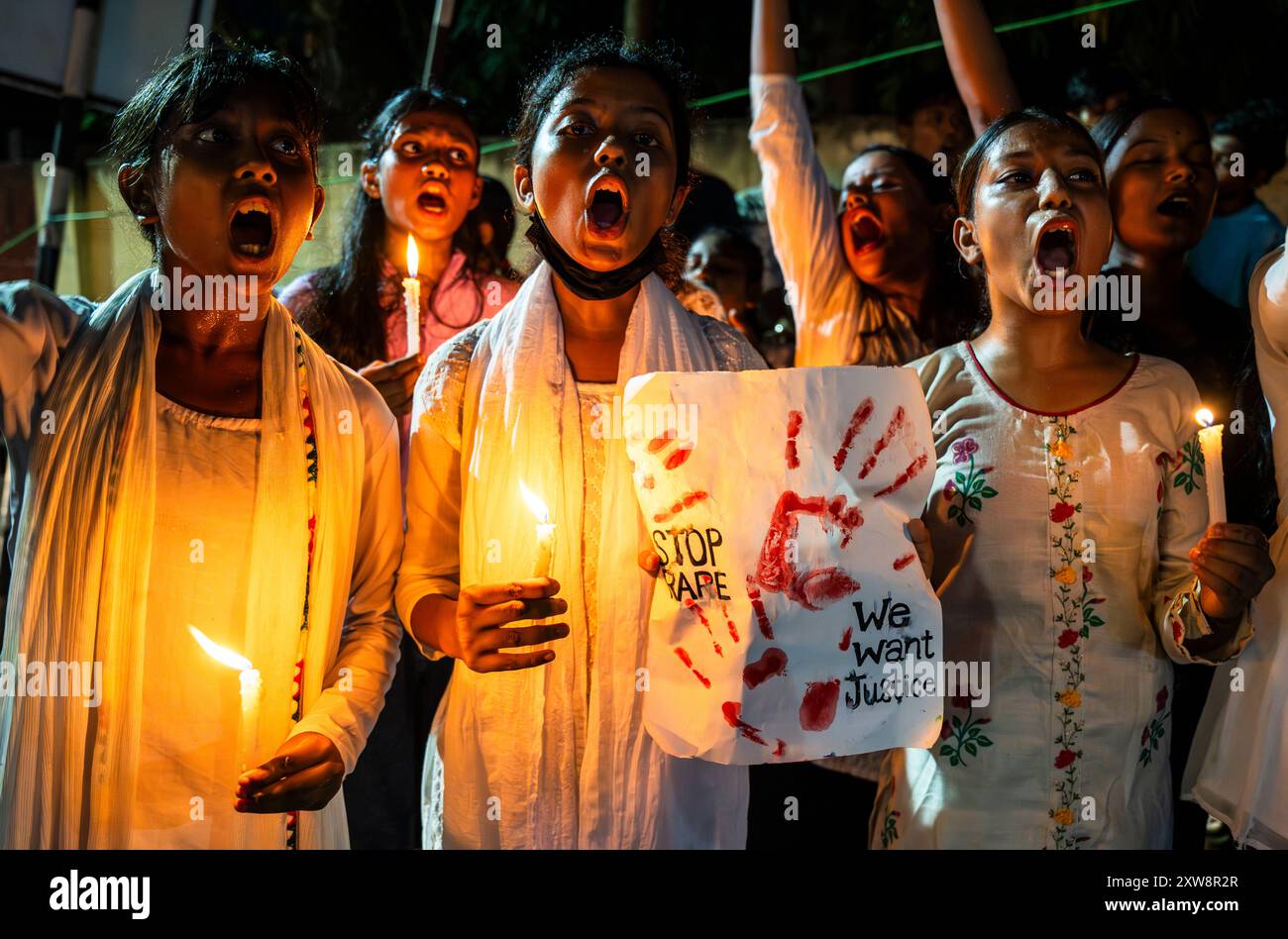 Studenten halten Kerzen und schreien Slogans, während sie an einem Protest gegen die Vergewaltigung und Ermordung eines Arztes in einem Krankenhaus in Kalkutta, am 18. August 2024 in Guwahati, Indien, teilnehmen. Ein Arzt, 31 Jahre alt, wurde letzte Woche am RG Kar Medical College and Hospital in Kalkutta, der Hauptstadt von Westbengalen, angegriffen. Quelle: David Talukdar/Alamy Live News Stockfoto