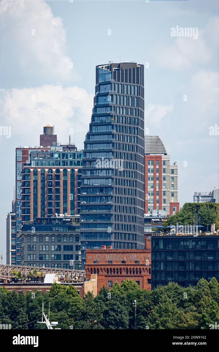 Riesige segelförmige Olympia DUMBO Eigentumswohnungen erhebt sich hinter dem Wahrzeichen Eagle Warehouse & Storage in dieser Aussicht von einer East River Fähre. Stockfoto