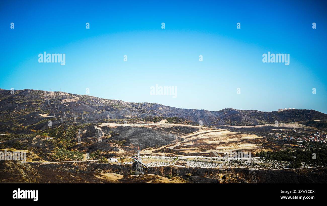Das am 15. August auf dem Yamanlar in Izmir ausgebrochene Waldfeuer breitete sich aufgrund des Windes über ein weites Gebiet aus. Der Brand betraf auch Wohn- und Industriebereiche. 17 Häuser wurden bei dem Brand verbrannt, 105 Häuser wurden evakuiert. 44 Arbeitsplätze wurden ebenfalls evakuiert. Der Brand, der die Evakuierung von 3 Stadtteilen verursachte, betraf eine Fläche von ​​approximately 1600 Hektar. Während es bei dem Feuer keinen Menschenleben gab, starben einige Tiere in den Dörfern. Das Waldfeuer in Izmir Yamanlar wurde unter Kontrolle gebracht und gelöscht. Stockfoto