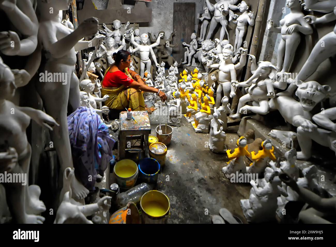 Kalkutta, Indien. August 2024. Vor dem bevorstehenden Viswakarma-Festival verleiht eine Künstlerin den Idolen des Hindu-Lord Viswakarma in dem Geschäft in der Gegend von Kumortuli, wo religiöse Statuen gefertigt werden, einen letzten Schliff. Das Ganesh Chaturthi Festival ist das jährliche Gottesfest der Hindus und es wird angenommen, dass Lord Ganesha der Gott der Neuanfänge und der Beseitigung von Hindernissen sowie der Gott der Weisheit, Intelligenz, des Reiches und des Wohlstands ist. Quelle: SOPA Images Limited/Alamy Live News Stockfoto