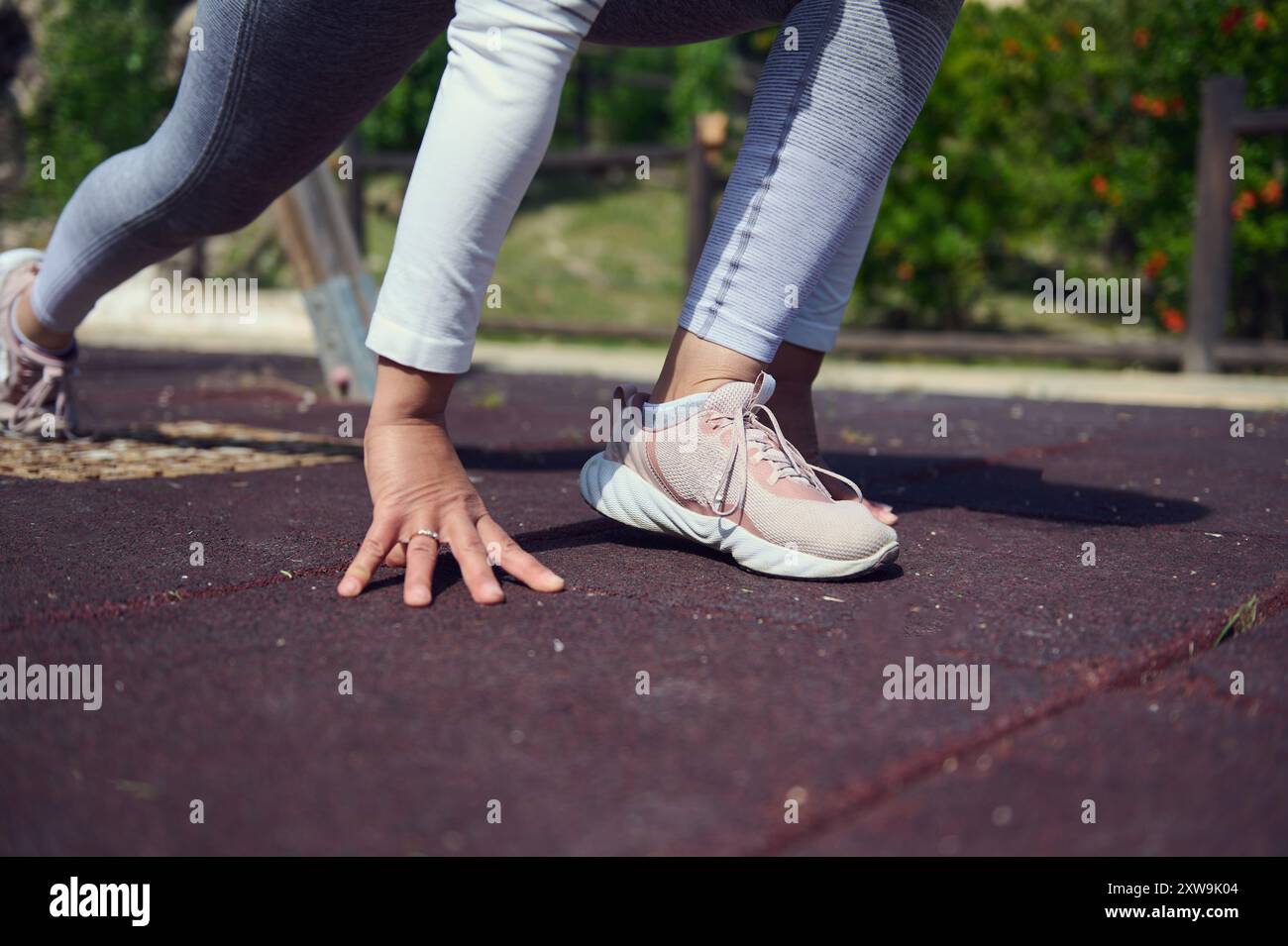 Füße und Hände des Athleten sind bereit für einen Sprint auf der Strecke, was für Bereitschaft, Fitness und ein Engagement für einen aktiven Lebensstil steht. Stockfoto