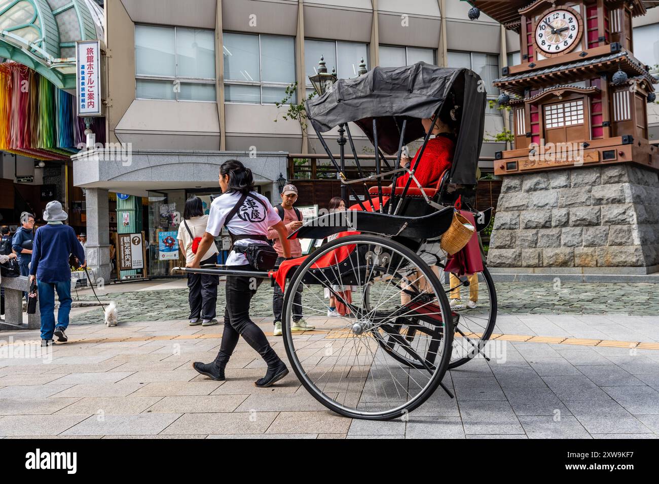Eine traditionelle Rikscha, ein zweirädriger Wagen gezogen kaufen eine Frau, in Dogo Yunomachi, Matsuyama Stadtzentrum, Shikoku Region, Japan Stockfoto
