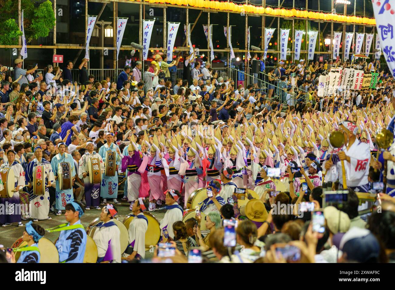 Tokushima Awa Odori Festival 2024 Soodori. Alle Darsteller tanzen und singen in einer Formation, während sie nachts durch die Bühne im Freien ziehen. Stockfoto