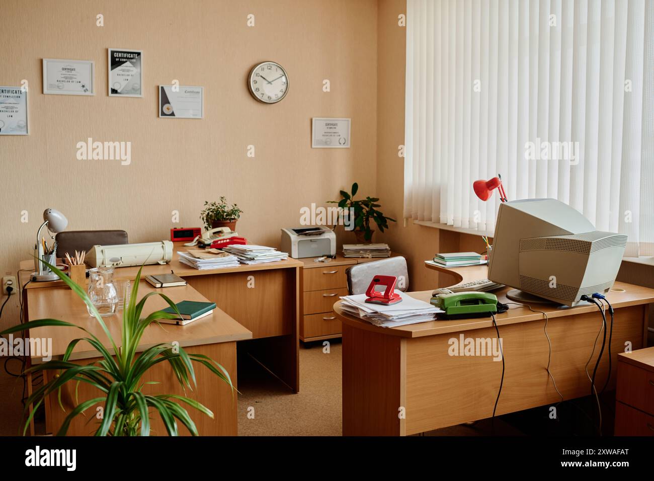 Gut organisierter Bürobereich mit Schreibtischen, Computern, Anlagen und Dokumenten Schaffung einer effizienten und einladenden Arbeitsumgebung Stockfoto