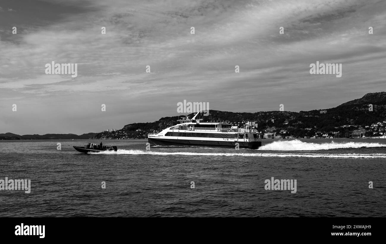 Hochgeschwindigkeits-Passagierkatamaran Admiralen in Byfjorden, Abfahrt vom Hafen Bergen, Norwegen. Ein kleines Hochgeschwindigkeitsboot, das in höherer Geschwindigkeit vorbeifährt Stockfoto