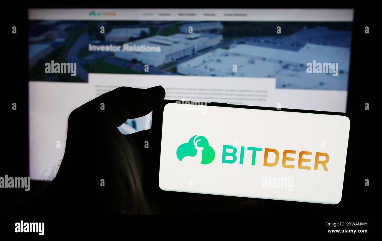 Person, die ein Smartphone mit dem Logo des singapurischen Blockchain-Unternehmens Bitdeer Technologies Group vor der Website hält. Schwerpunkt auf dem Display des Telefons. Stockfoto