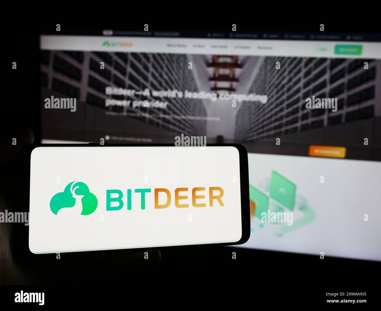 Person, die ein Mobiltelefon mit dem Logo des singapurischen Blockchain-Unternehmens Bitdeer Technologies Group vor der Webseite hält. Schwerpunkt auf dem Display des Telefons. Stockfoto