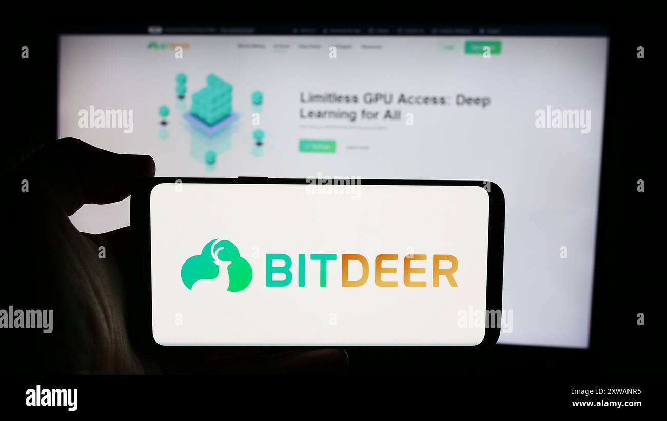Person, die ein Mobiltelefon mit dem Logo des singapurischen Blockchain-Unternehmens Bitdeer Technologies Group vor der Webseite hält. Schwerpunkt auf dem Display des Telefons. Stockfoto