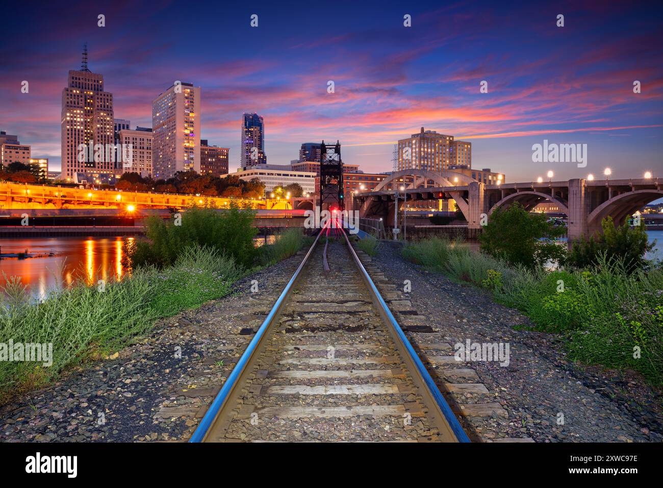 Saint Paul, Minnesota, USA. Stadtbild der Innenstadt von St. Paul, Minnesota, USA, mit Eisenbahnschienen, die bei schönem Sommeruntergang in die Stadt führen. Stockfoto