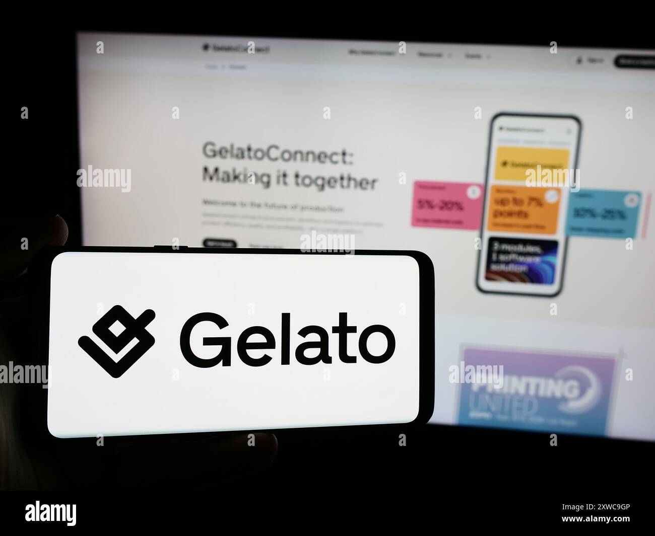 Person mit Smartphone und Logo des norwegischen Print-on-Demand-Unternehmens Gelato ASA vor der Website. Schwerpunkt auf dem Display des Telefons. Stockfoto
