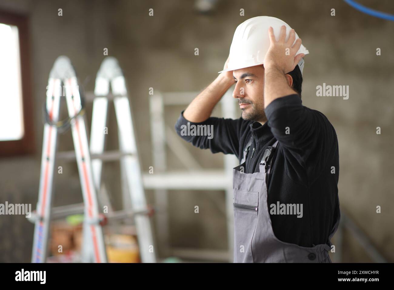 Bauarbeiter mit Helm in einem Haus, das gerade reformiert wird Stockfoto