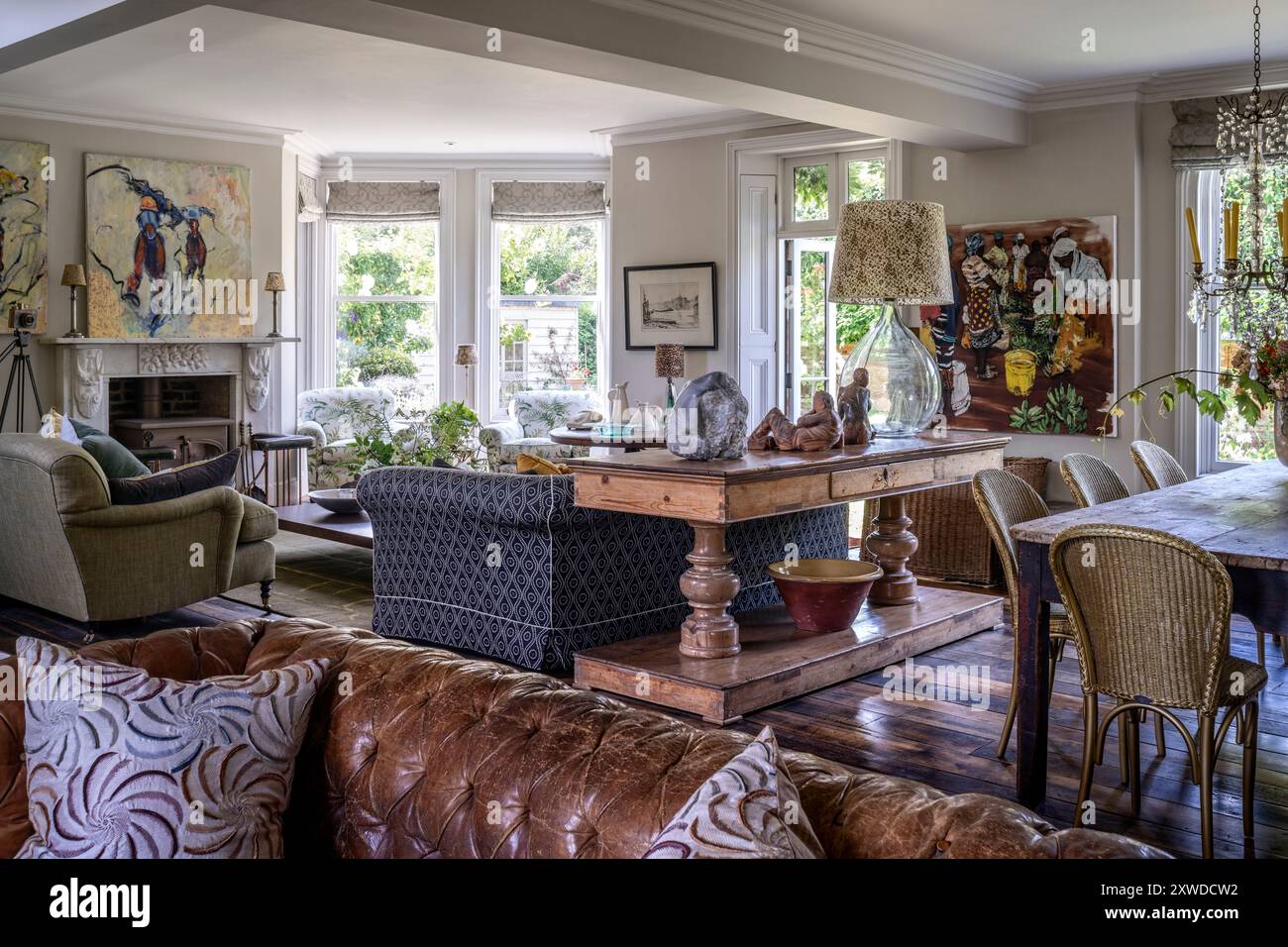 Offen geschnittenes Wohn- und Esszimmer mit modernen Kunstwerken in Wimbledon Home, Südwest-London, England, Großbritannien. Stockfoto