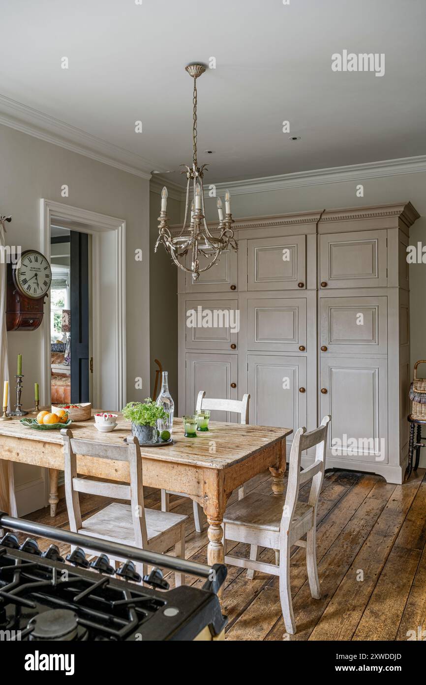 Bauernhaus Küche mit Wanduhr und großem Schrank in Wimbledon Home, Südwest London, England, Großbritannien. Stockfoto
