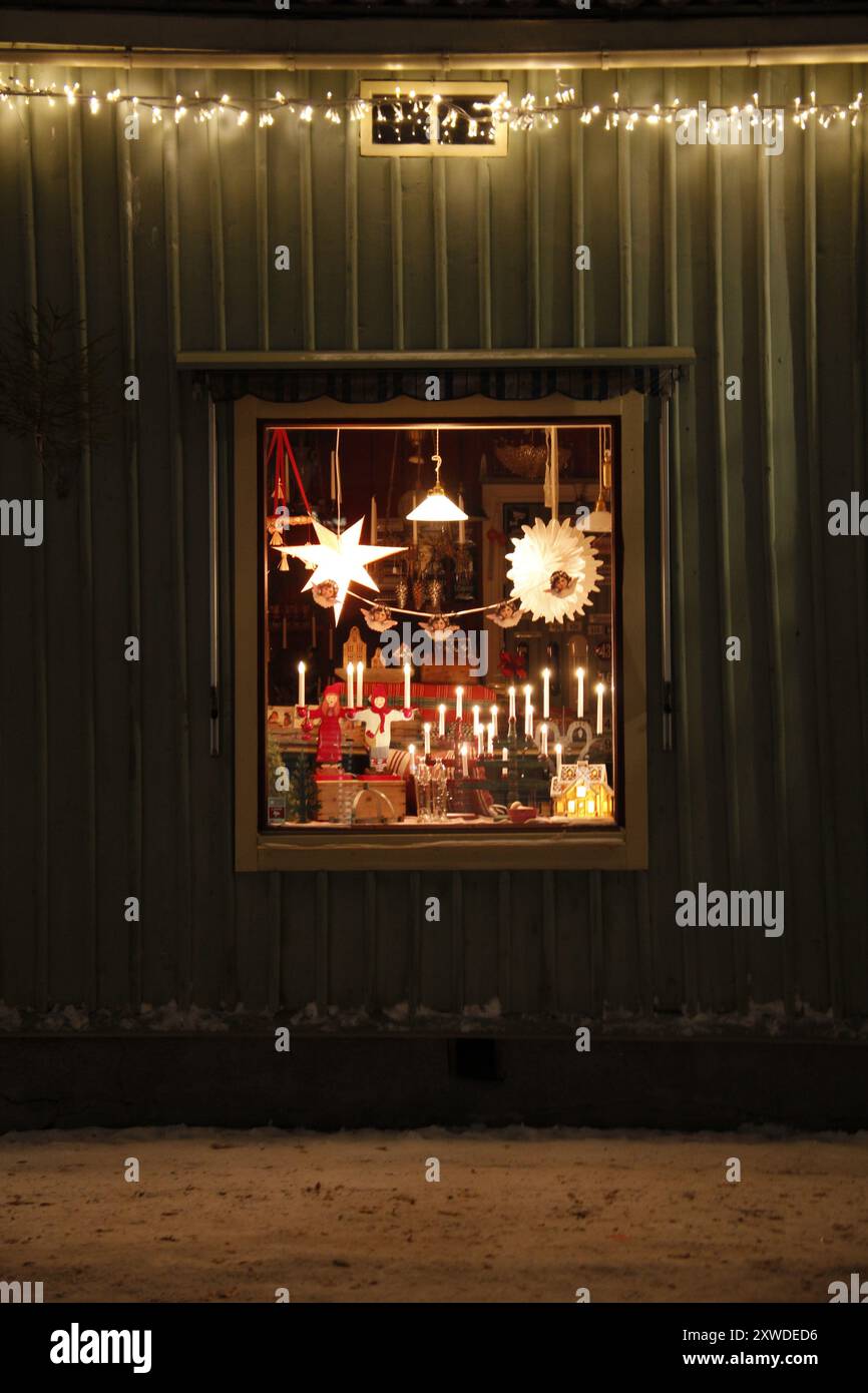 Beleuchtete Fenster im Weihnachtsgeschäft in der malerischen schwedischen Kleinstadt Nora. Stockfoto