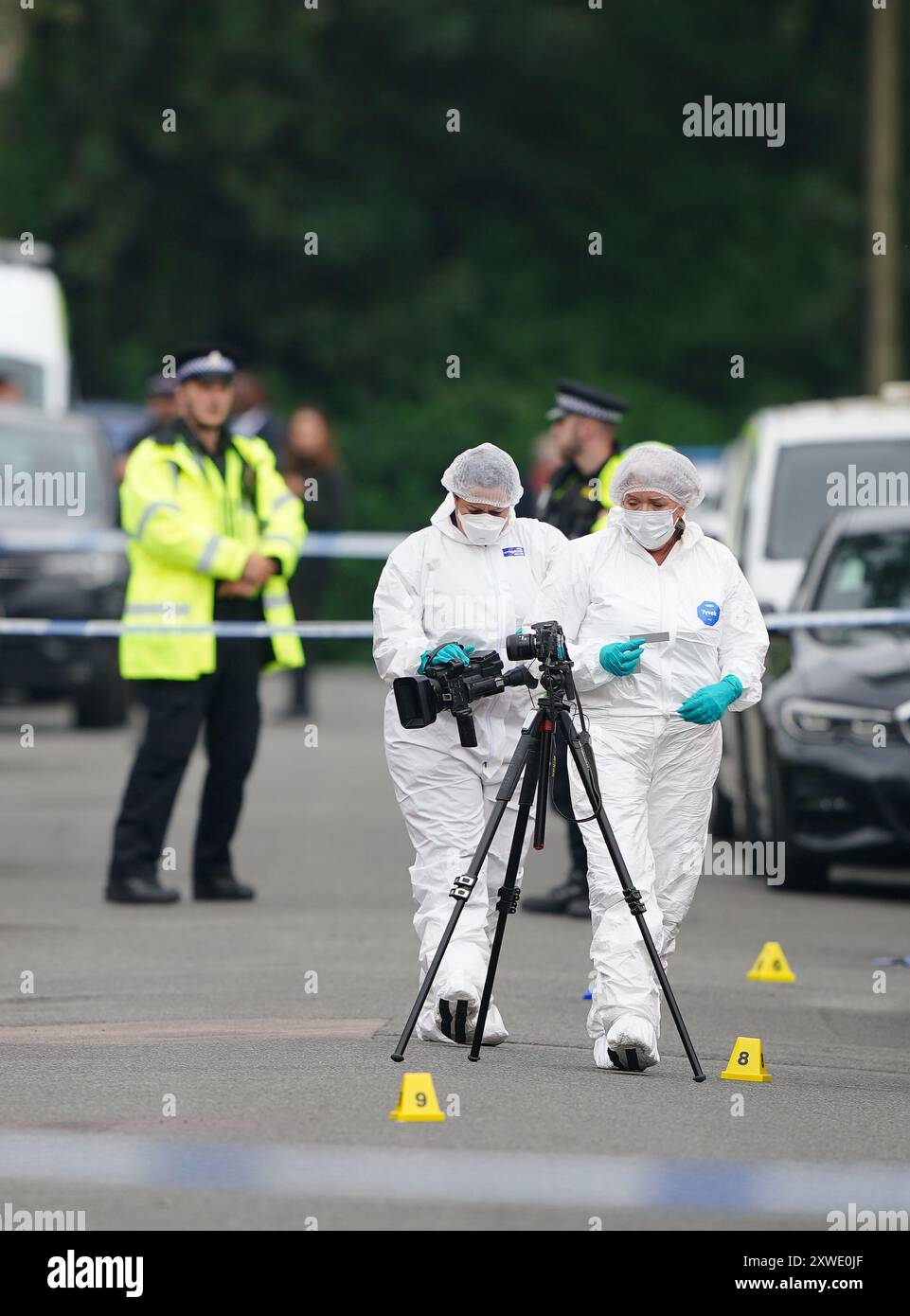 Gerichtsmediziner in der Nähe eines Anwesens in der Barnard Road in Gorton, Manchester, wo am Sonntagabend drei Personen mit schweren Stichverletzungen gerufen wurden. Eine 43-jährige Frau starb am Tatort, und ein 17-jähriges Mädchen und ein 64-jähriger Mann werden im Krankenhaus behandelt. Ein 22-jähriger Mann wurde wegen Mordverdacht verhaftet. Bilddatum: Montag, 19. August 2024. Stockfoto