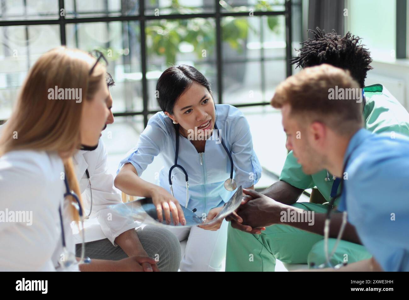 Gruppe von multinationalen Ärzten für die Diskussion der Analyse im Konferenzraum Stockfoto