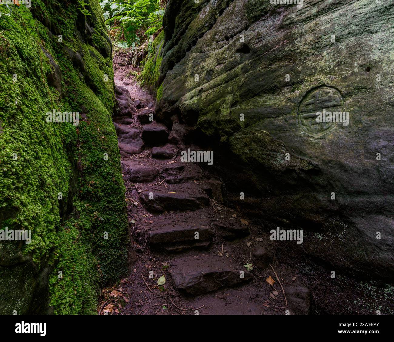 Auf dem Weg entlang der gewundenen Stufen, die in die Felsen gehauen sind, sind viele Radierungen wie keltische Kreuze, menschliche Gesichter und andere „mystische“ Symbole gemeißelt Stockfoto