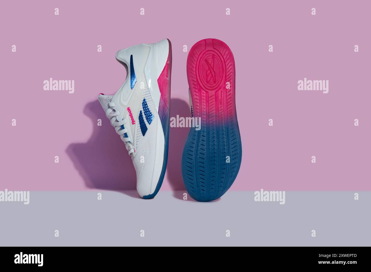 Straßburg, Frankreich - August 2024 : neue Trainingsschuhe Reebok Nano X4 auf rosa und weißem Hintergrund Seite und Sohle. Stylische, lebendige Schuhe für aktive Menschen Stockfoto