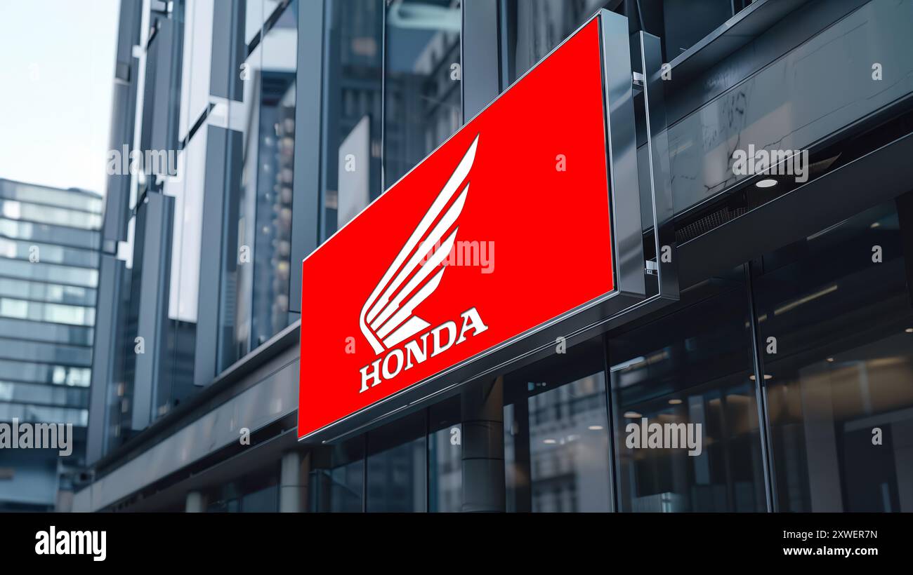 Beleuchtetes Banner mit dem Logo des honda Autoherstellers auf einem Glasbürogebäude. Stockfoto