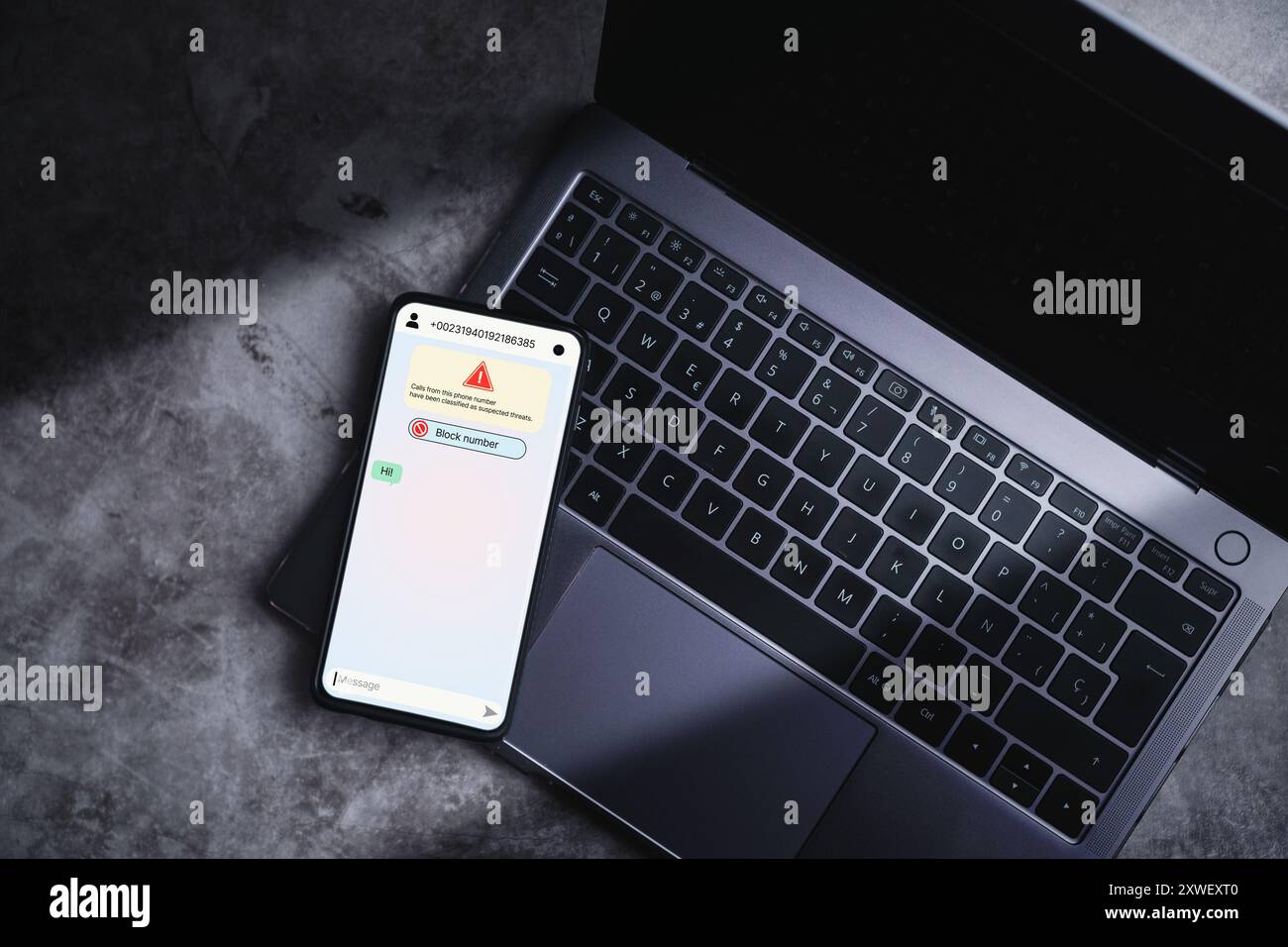 Smartphone, das auf dem Laptop liegt, empfängt eine Nachricht von mutmaßlichem Zahlenbetrug. Unerwünschter anonymer Anruf. Betrugs- und Phishing-Telefonkonzept. Nachricht von Fremdem. Stockfoto