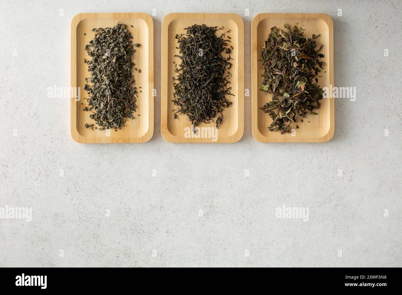 Eine Ansicht von oben nach unten auf Bambustabletts mit verschiedenen losen Blättern auf der Oberseite des Rahmens. Stockfoto