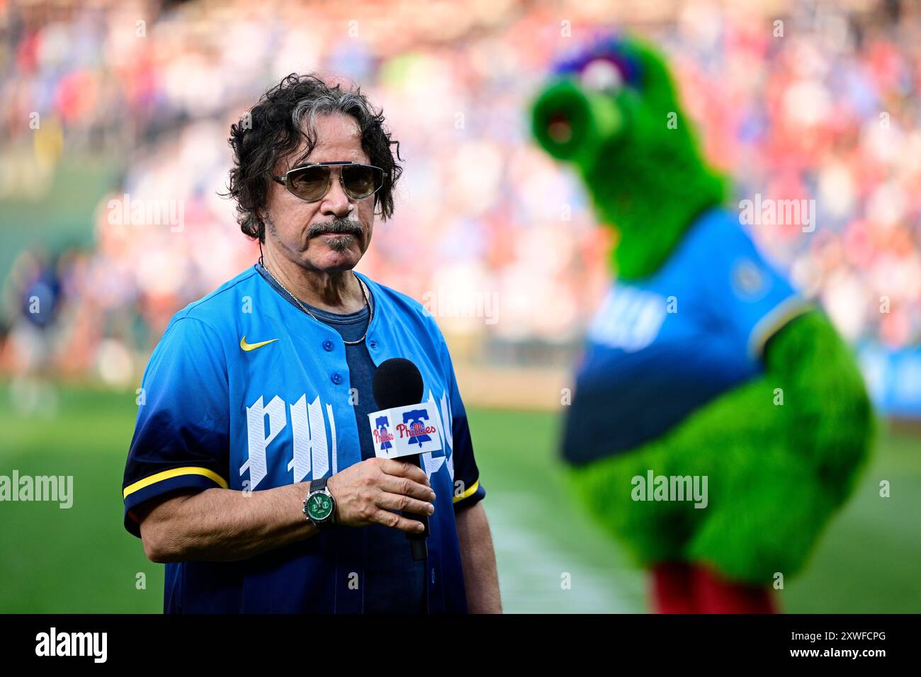 Rock and Roll Hall of Famer John Oates sings the national anthem prior to a baseball game between the Philadelphia Phillies and the Washington Nationals, Friday, Aug. 16, 2024, in Philadelphia. (AP Photo/Derik Hamilton) Stockfoto