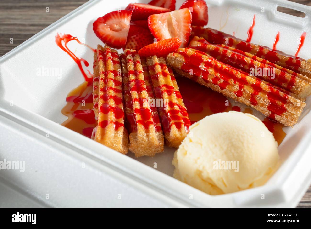 Blick auf einen Behälter mit Churros und eine Schaufel Eis. Stockfoto