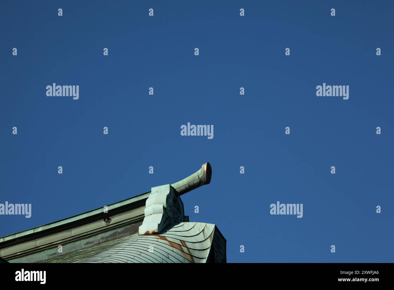 Die Ecke eines Tempelgebäudes ist vom blauen Himmel am Meiji-Schrein in Tokio, Japan, umgeben. Stockfoto