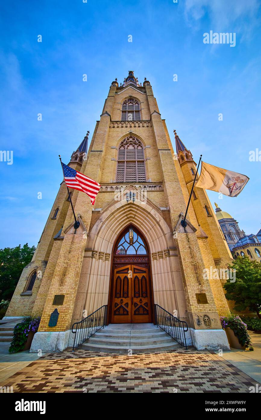 Gotische Kathedralfassade mit Blick nach oben auf die amerikanische Flagge Stockfoto
