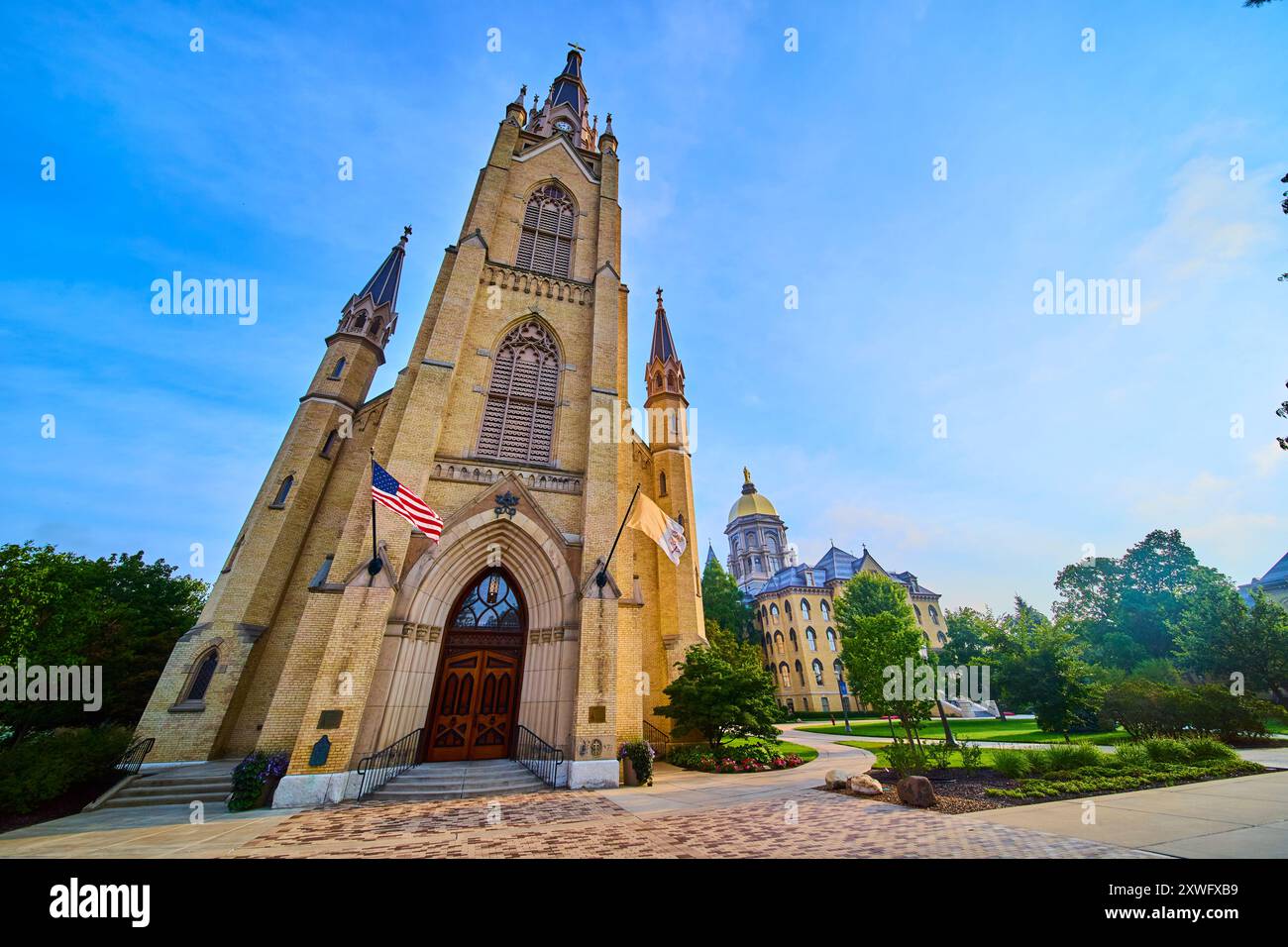 Basilika im gotischen Stil und Golden Dome auf dem üppigen Campus mit flachem Blick Stockfoto